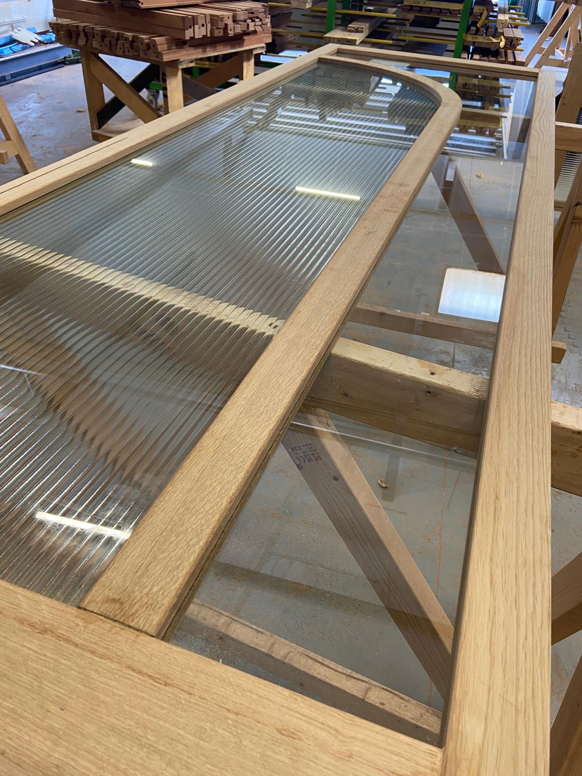 Eiken deur met glas en roedes in de werkplaats