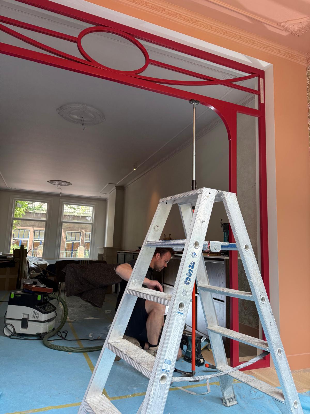 Montage van een rode maatwerk deur in een interieur