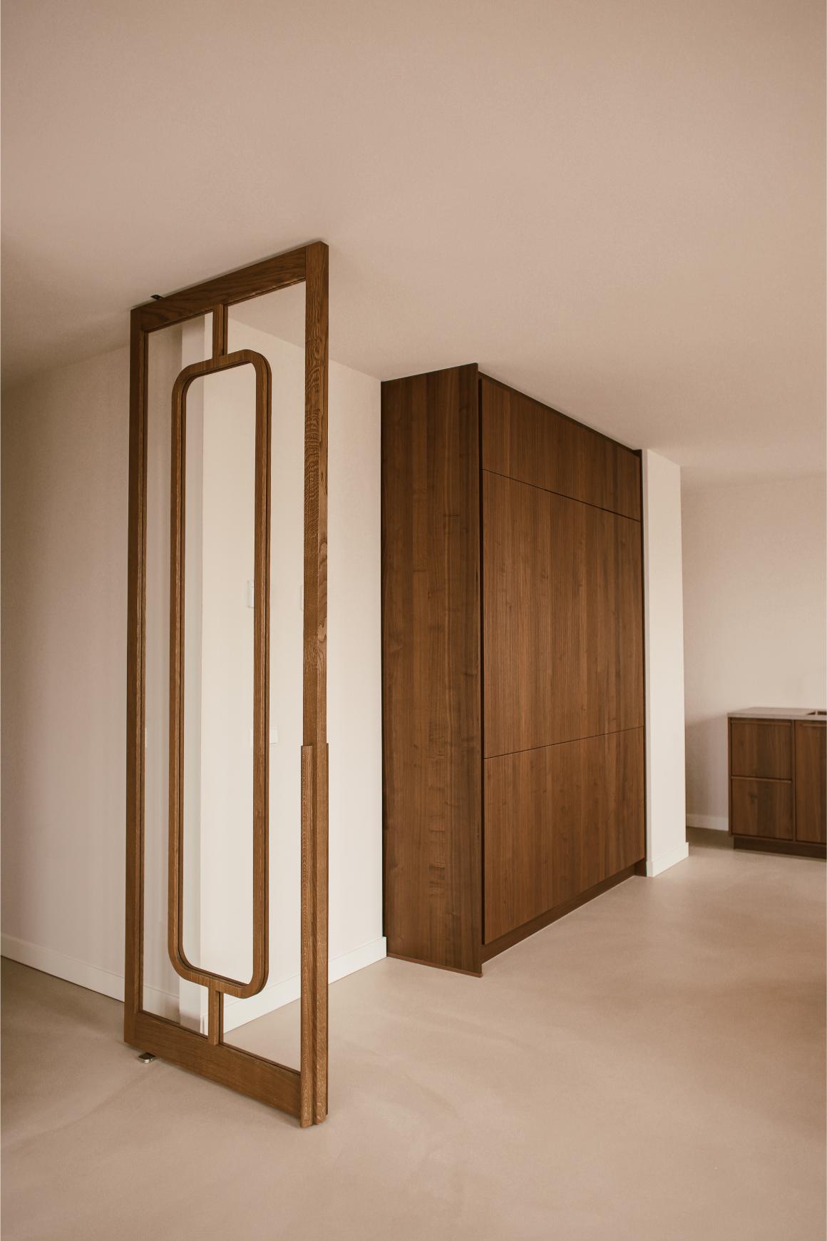 Onyx taatsdeur in walnootkleur met houten greep in een maatwerk interieur